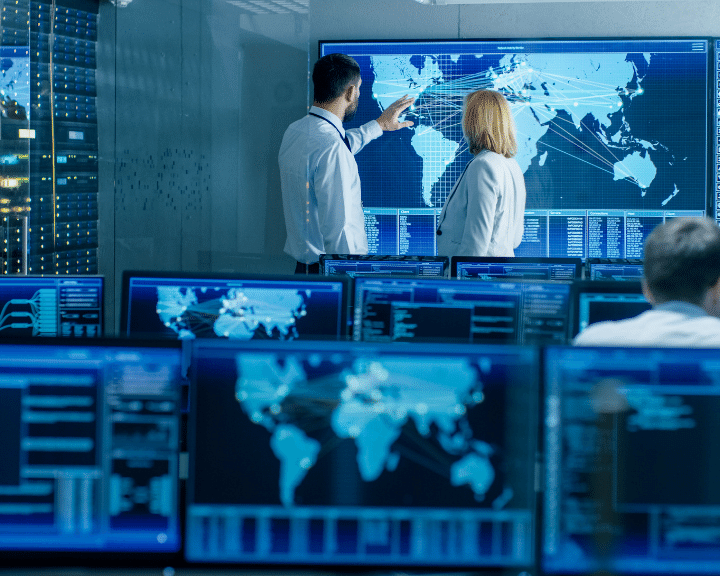 man and woman at supply chain control center Gain real-time visibility to container & vessel location through data feeds from 3rd-party service providers.