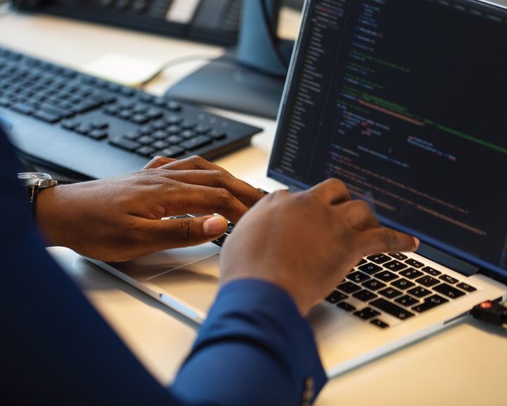 Working on a laptop, supply chain software code: become a Chain.io partner. 